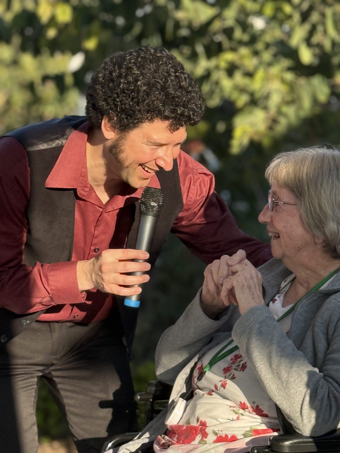 A musician shares a song with a resident at A Place Called Home, holding the microphone close as they sing together
