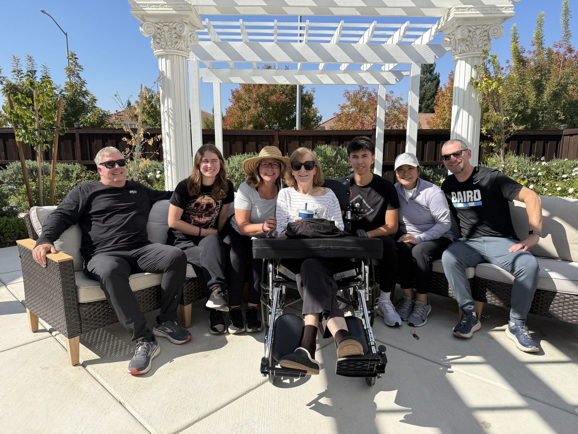 Staff and residents gathered together under the courtyard pergola at A Place Called Home