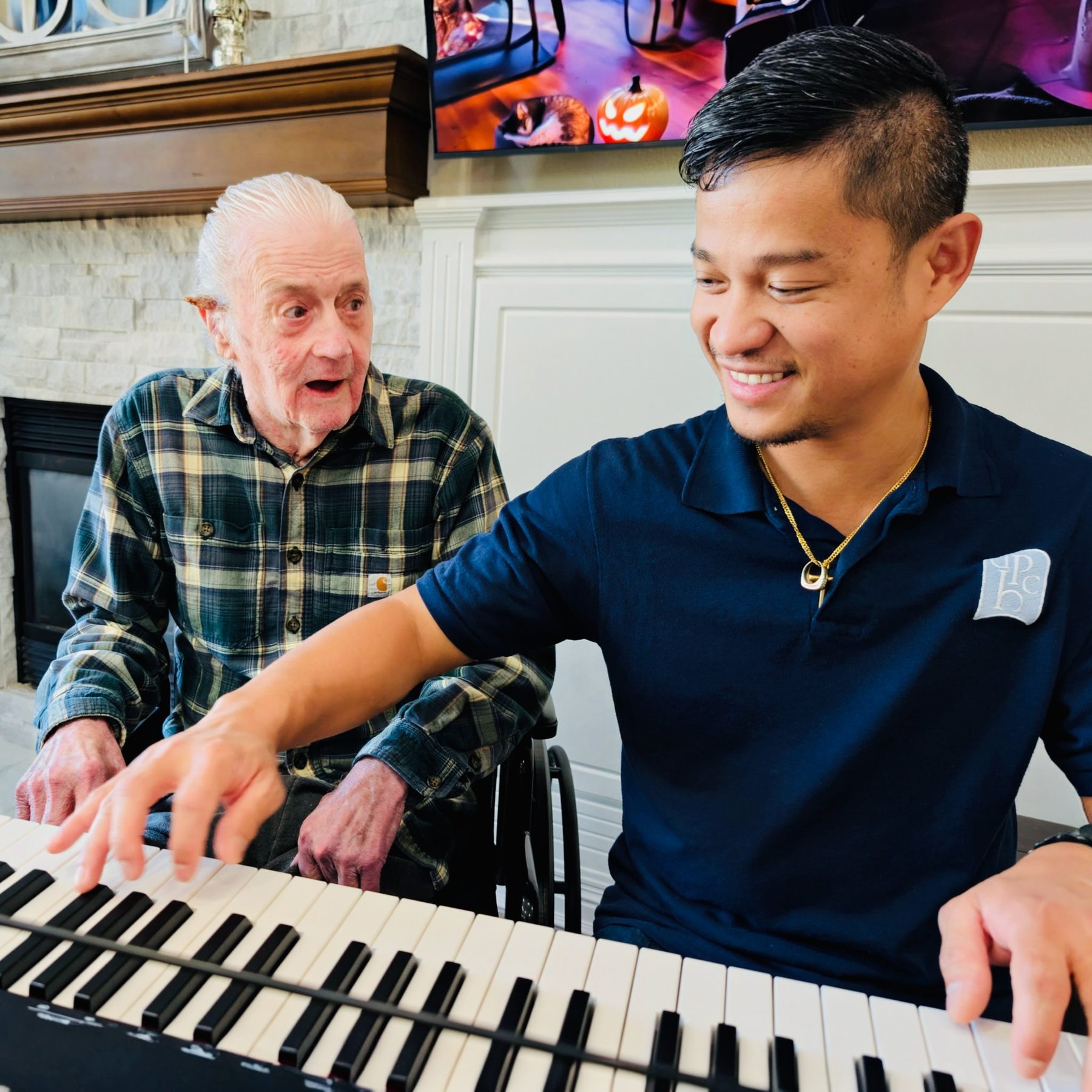A resident plays piano with a caregiver